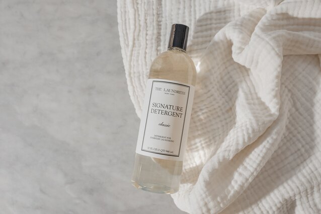 Signature Detergent The Laundress Signature Detergent Classic for everyday laundering sitting on a white fabric